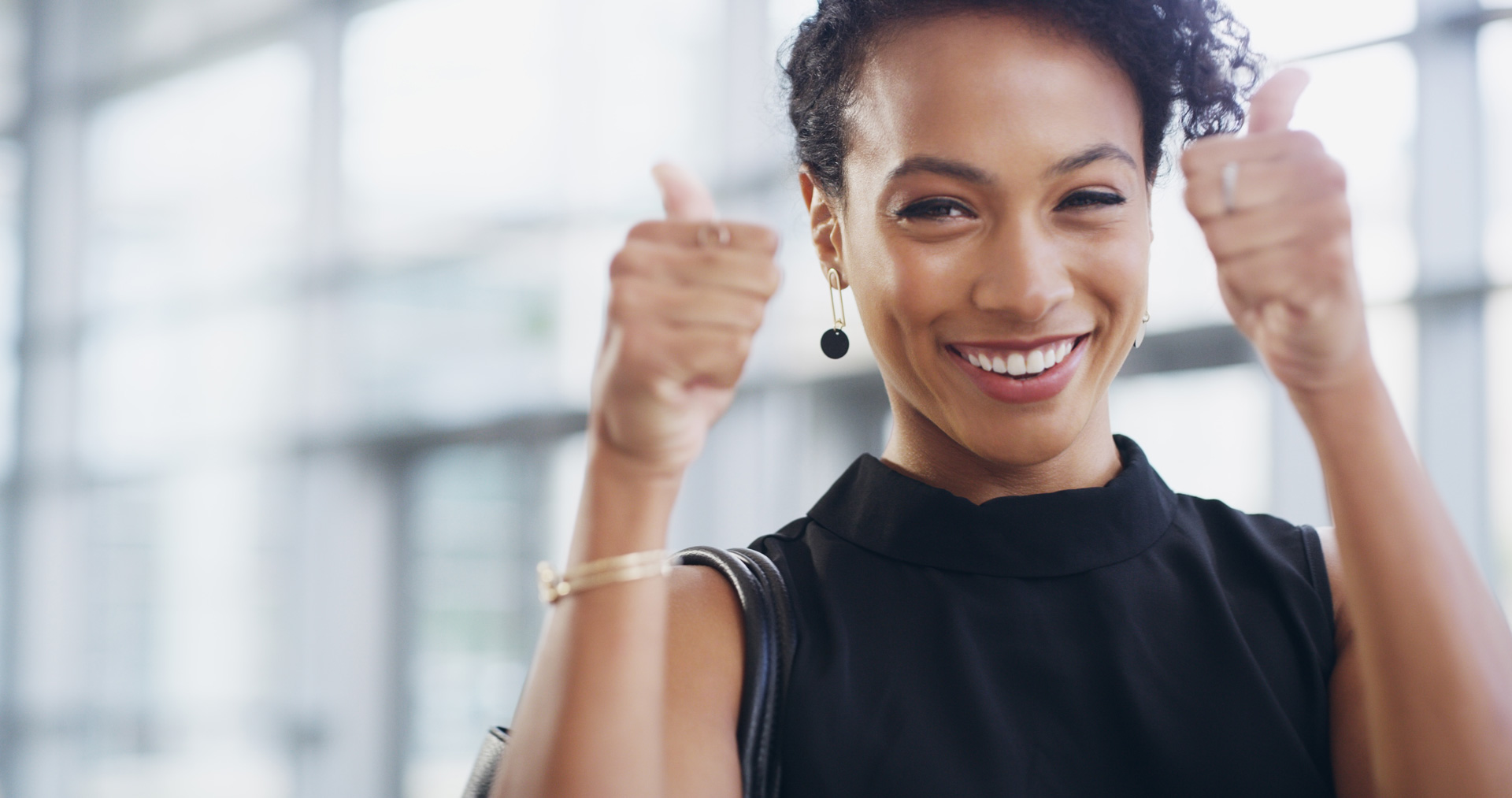 Woman smiling with both thumbs up for achieving customer success