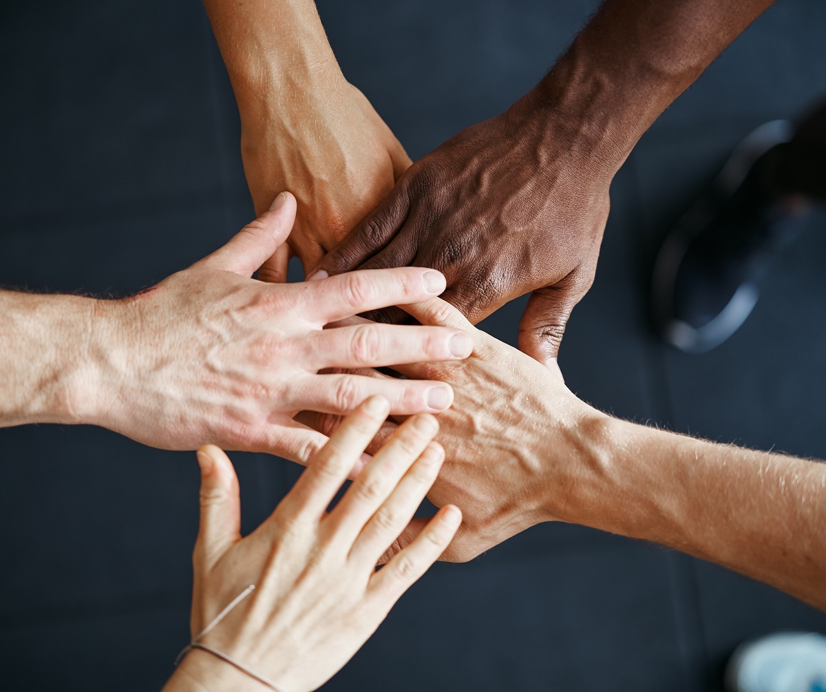 diverse hands coming together representing improving diversity in the contact center