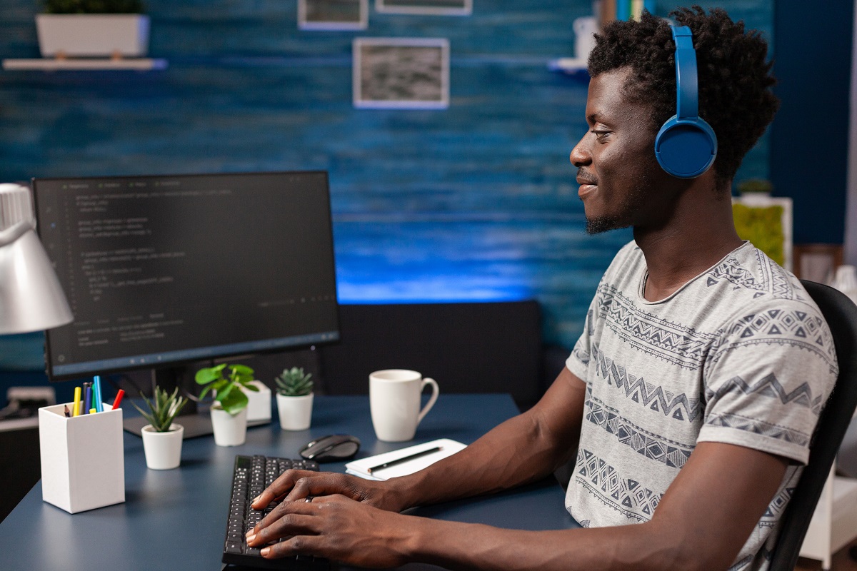 African american man programmer with headphones writing program code