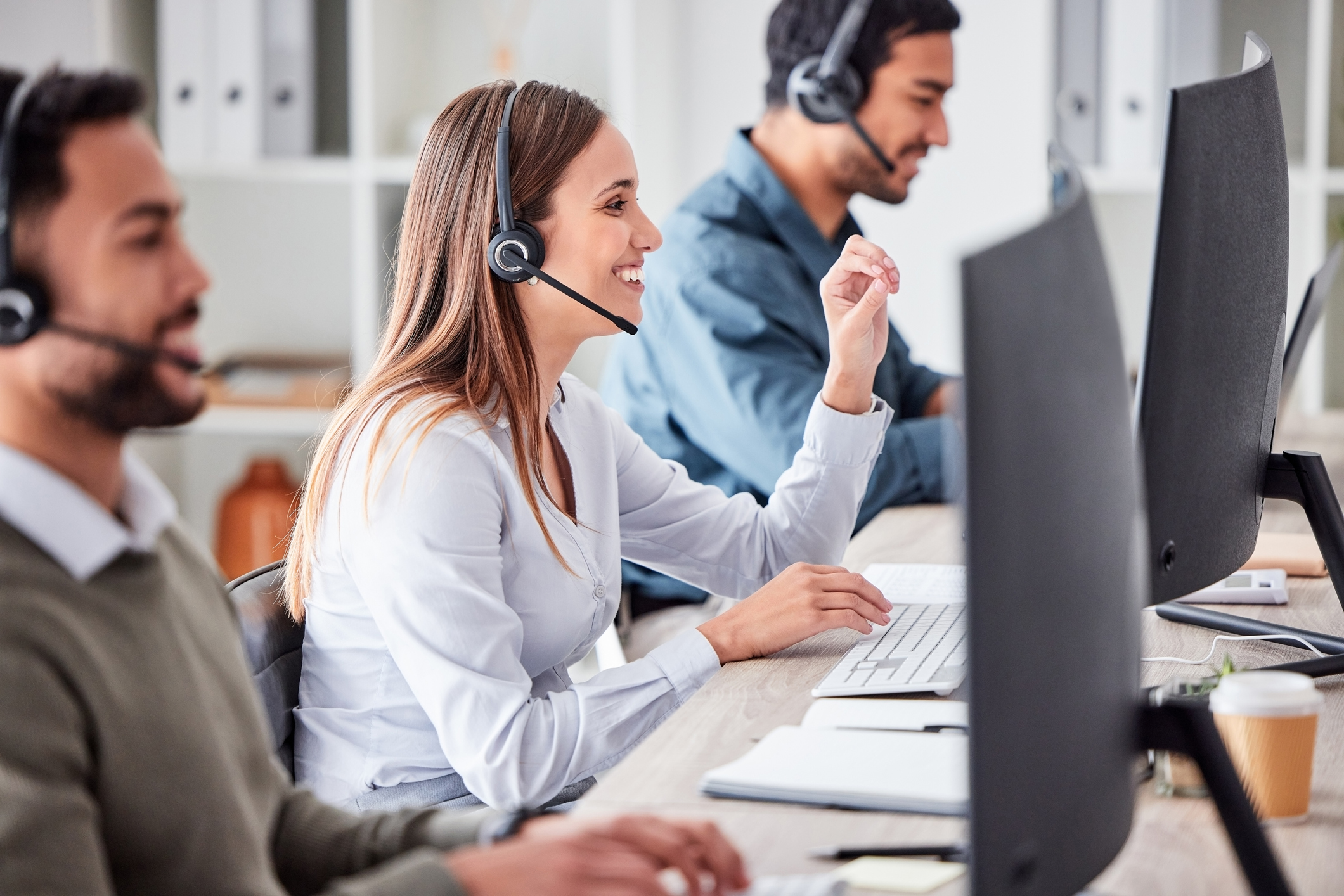 Employees answer incoming support calls at a customer support center.