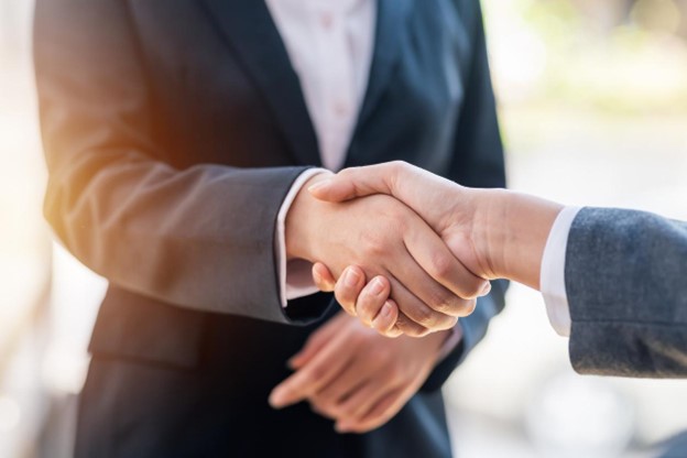 Two professionals shaking hands during a business deal