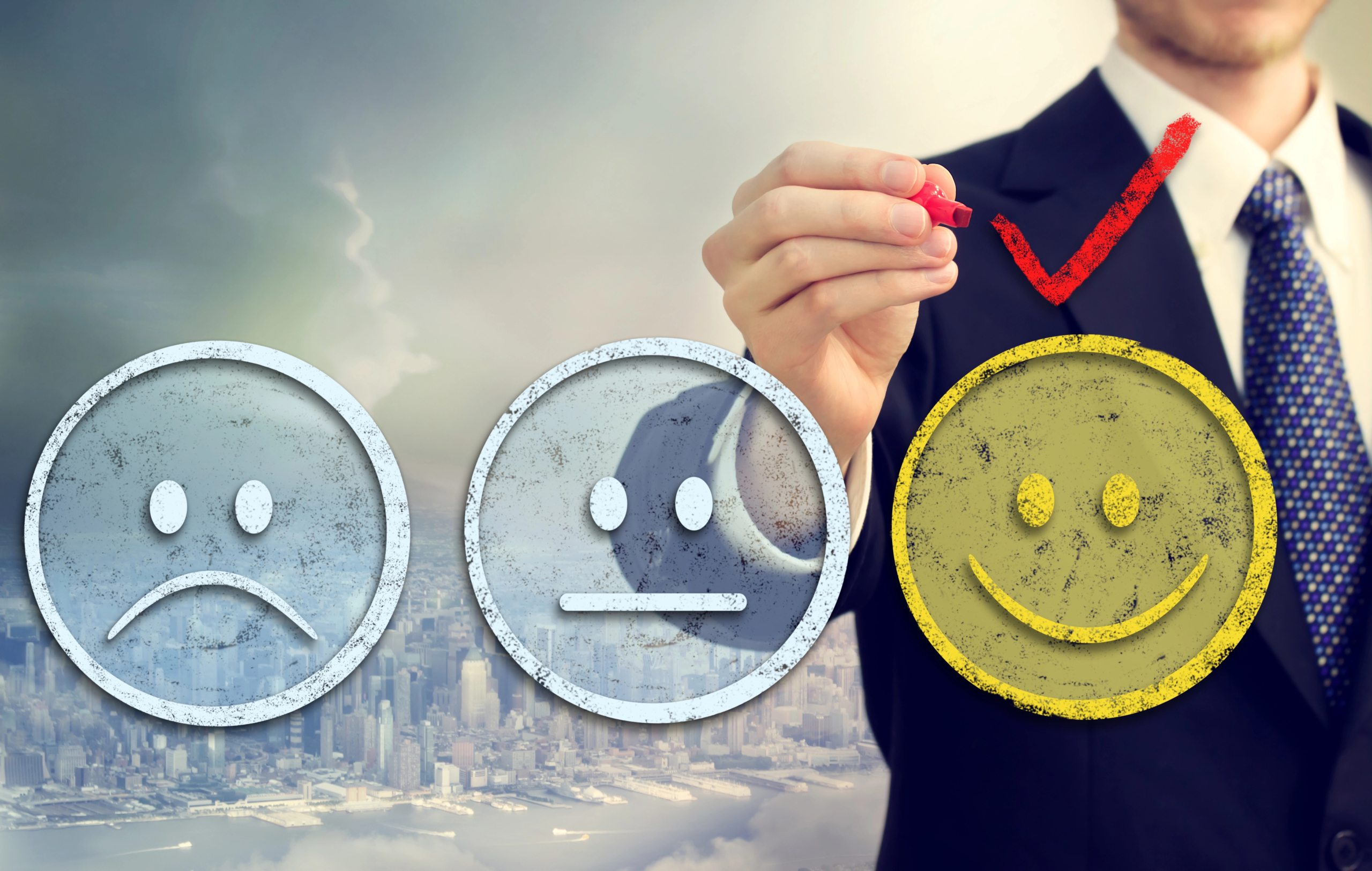 Man in business suit pointing to three superimposed faces indicating levels of customer satisfaction