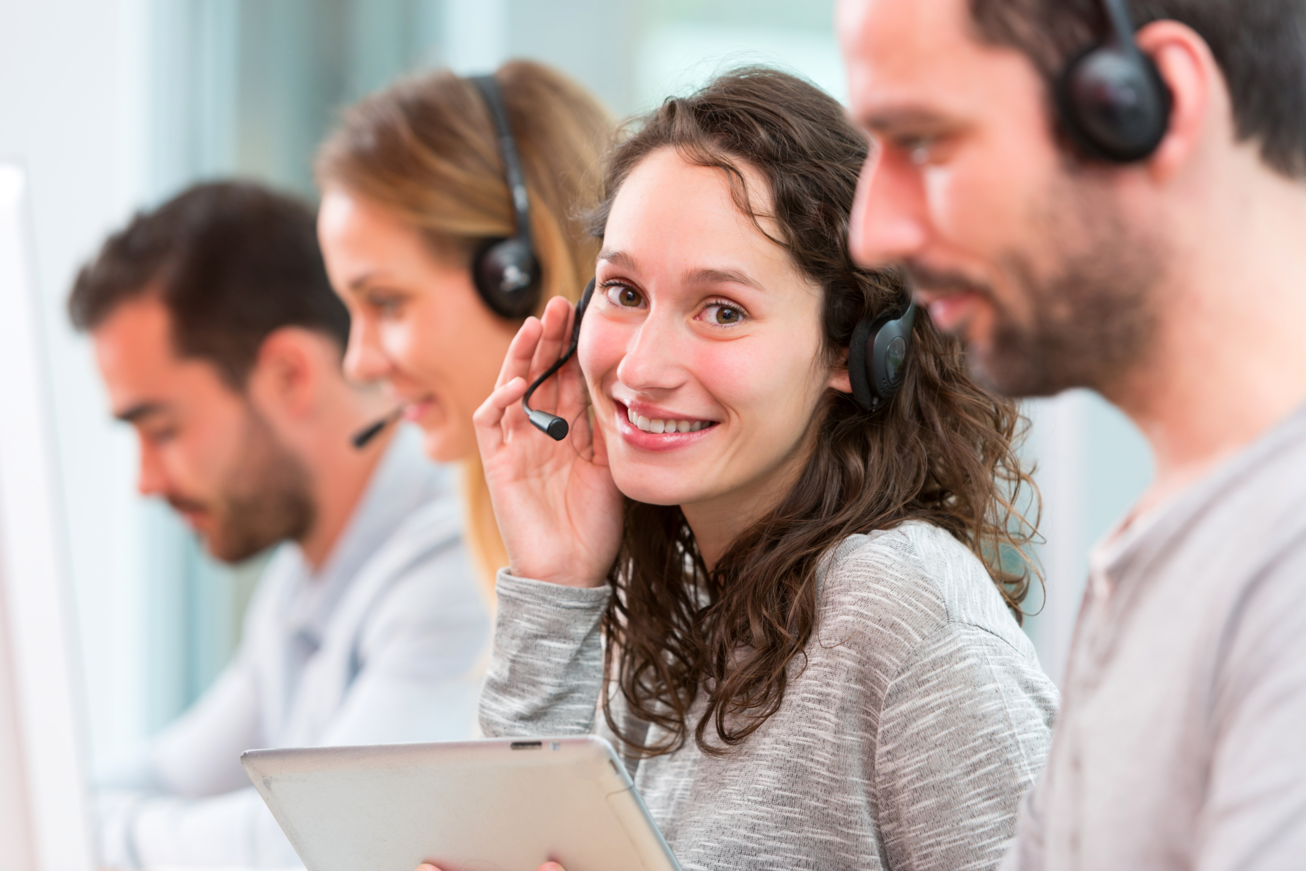 Female customer service representative wearing a headset and smiling at the camera