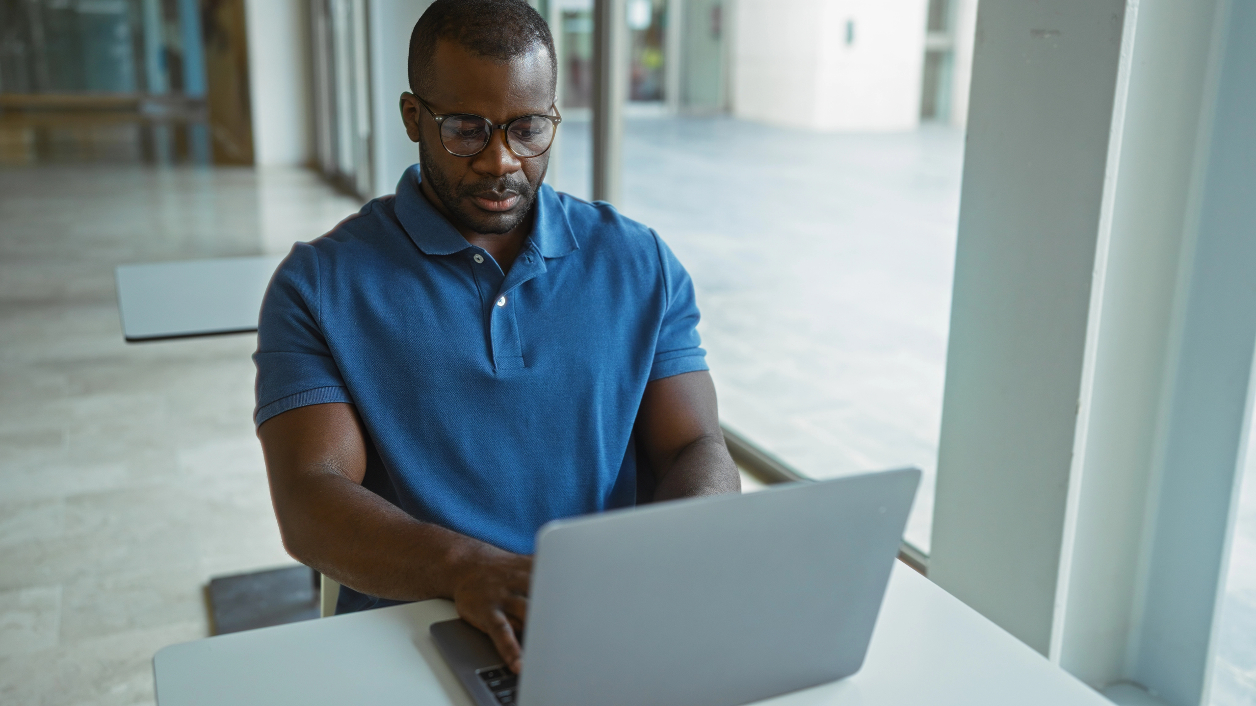 man sits in office with laptop computer and works on CX improvement