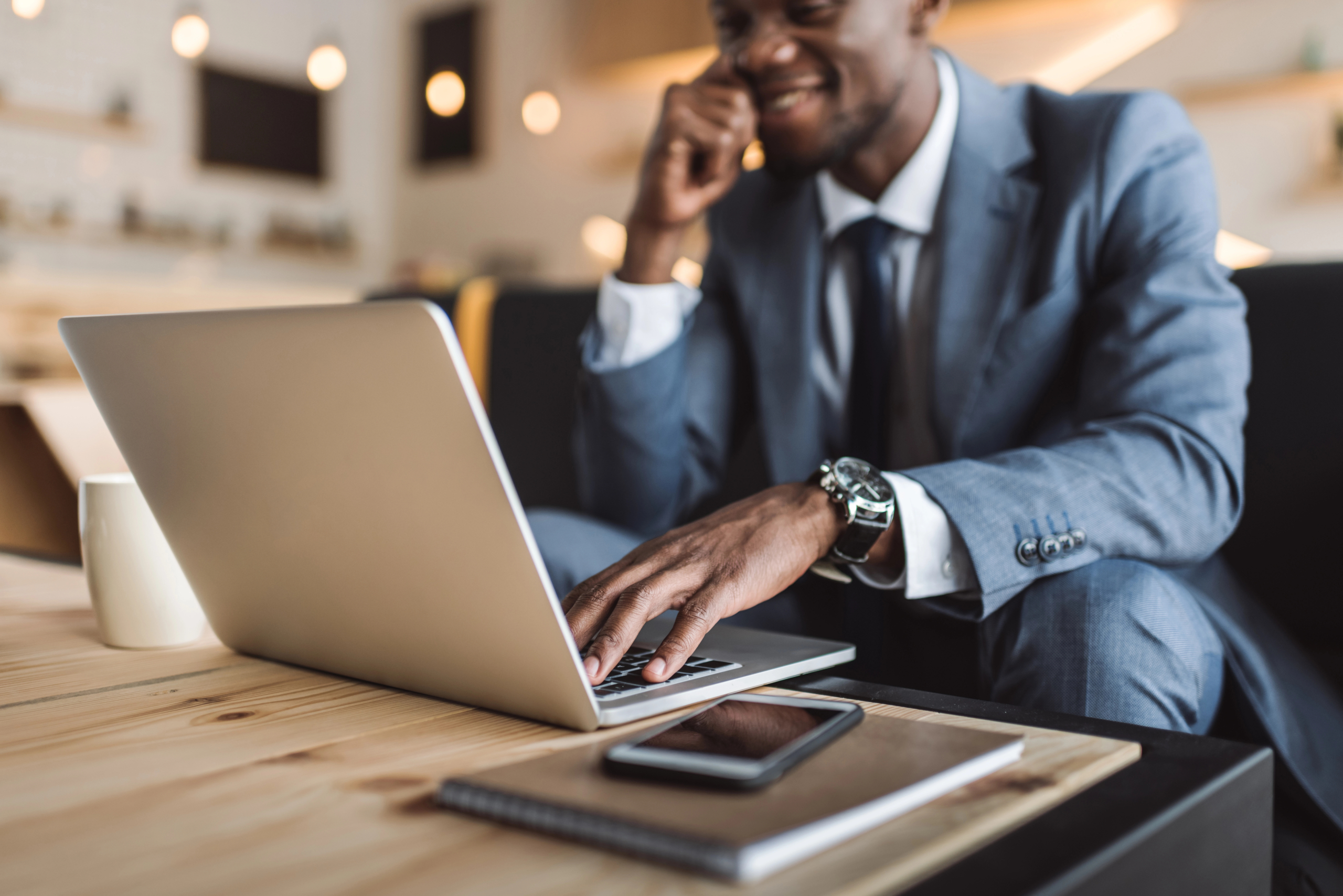 businessman sits in cafe with computer and works on subscription lifecycle management