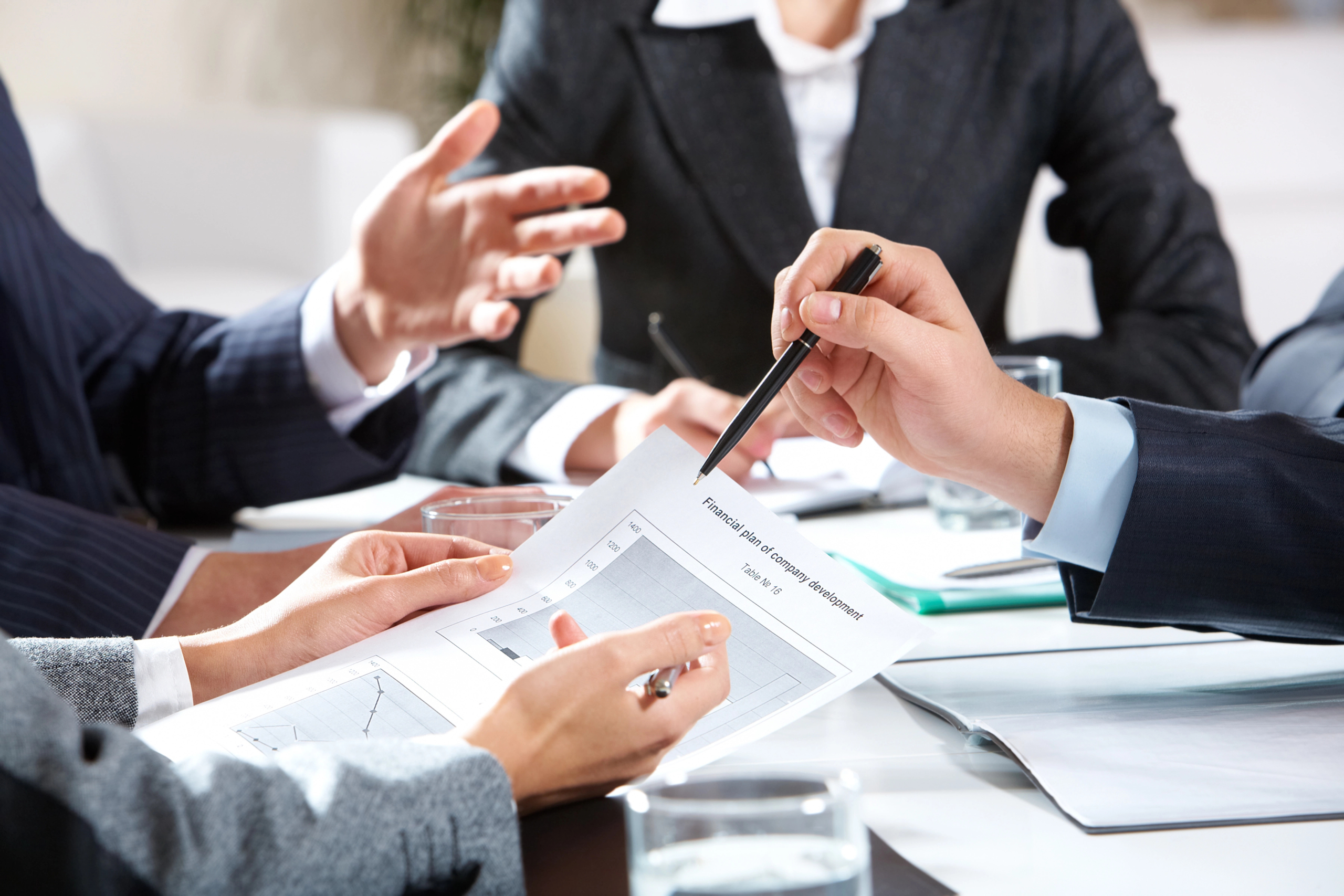 c-suite team sits in office at desk and reviews marketing attribution models