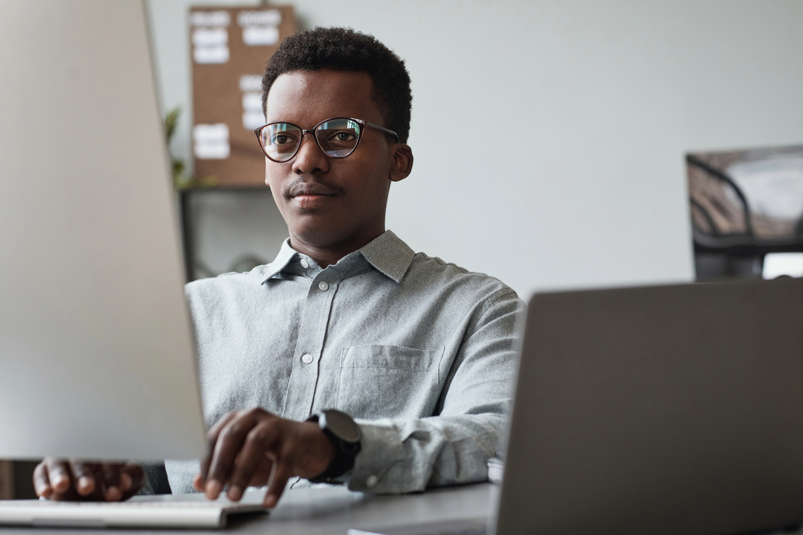 young businessman using computer at work to learn about sales outsourcing