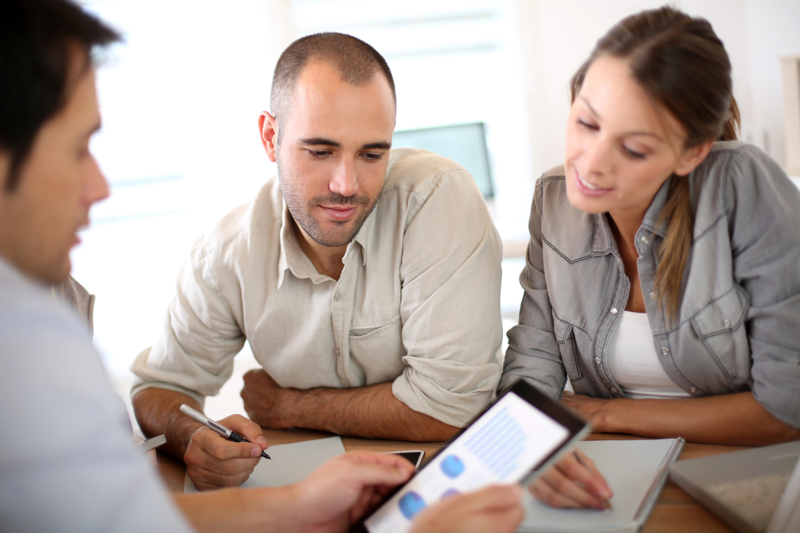 team sits at desk and reviews results on tablet after implementing AI for sales teams