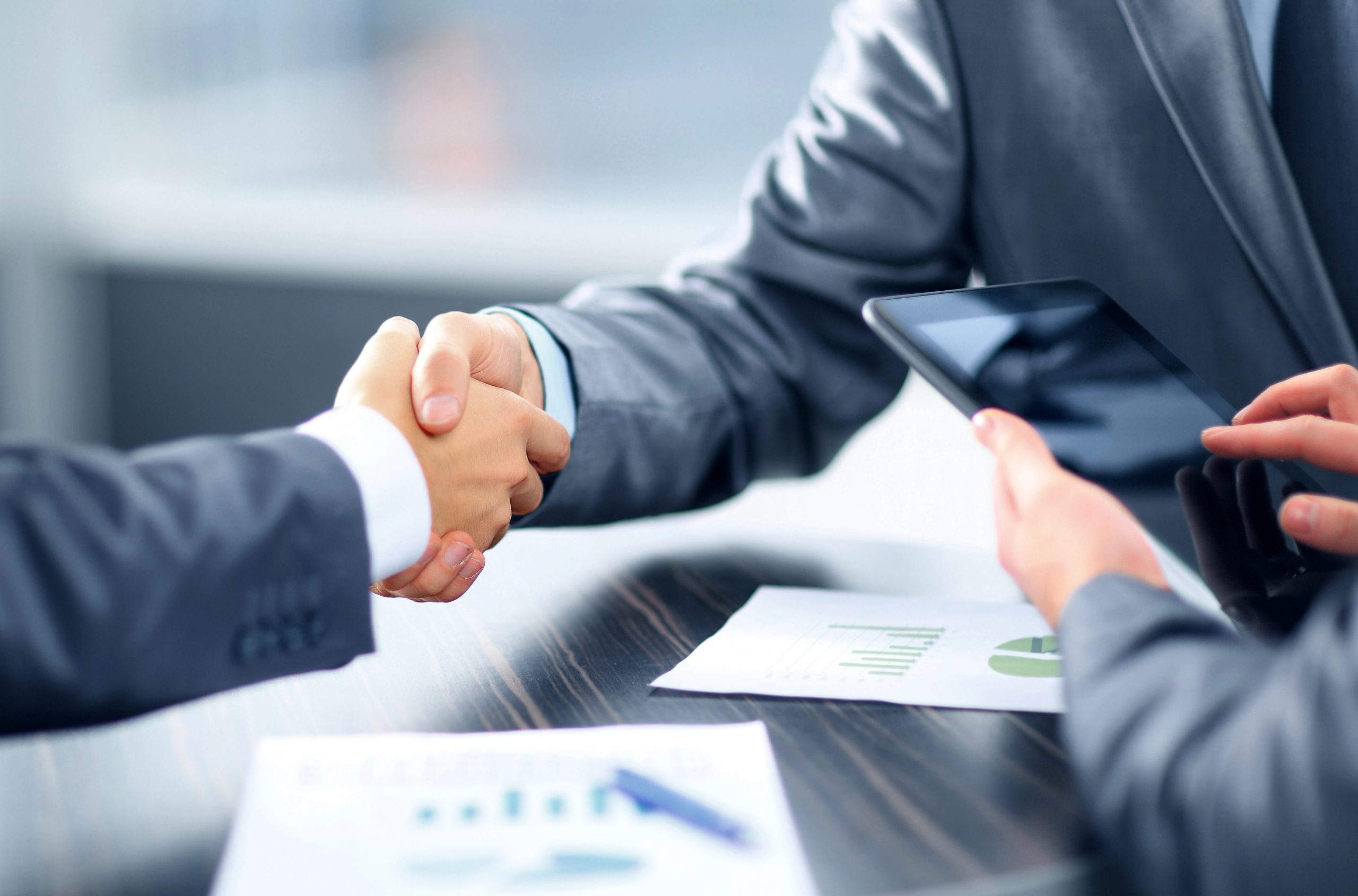 business people shake hands in office after implementing AI marketing automation