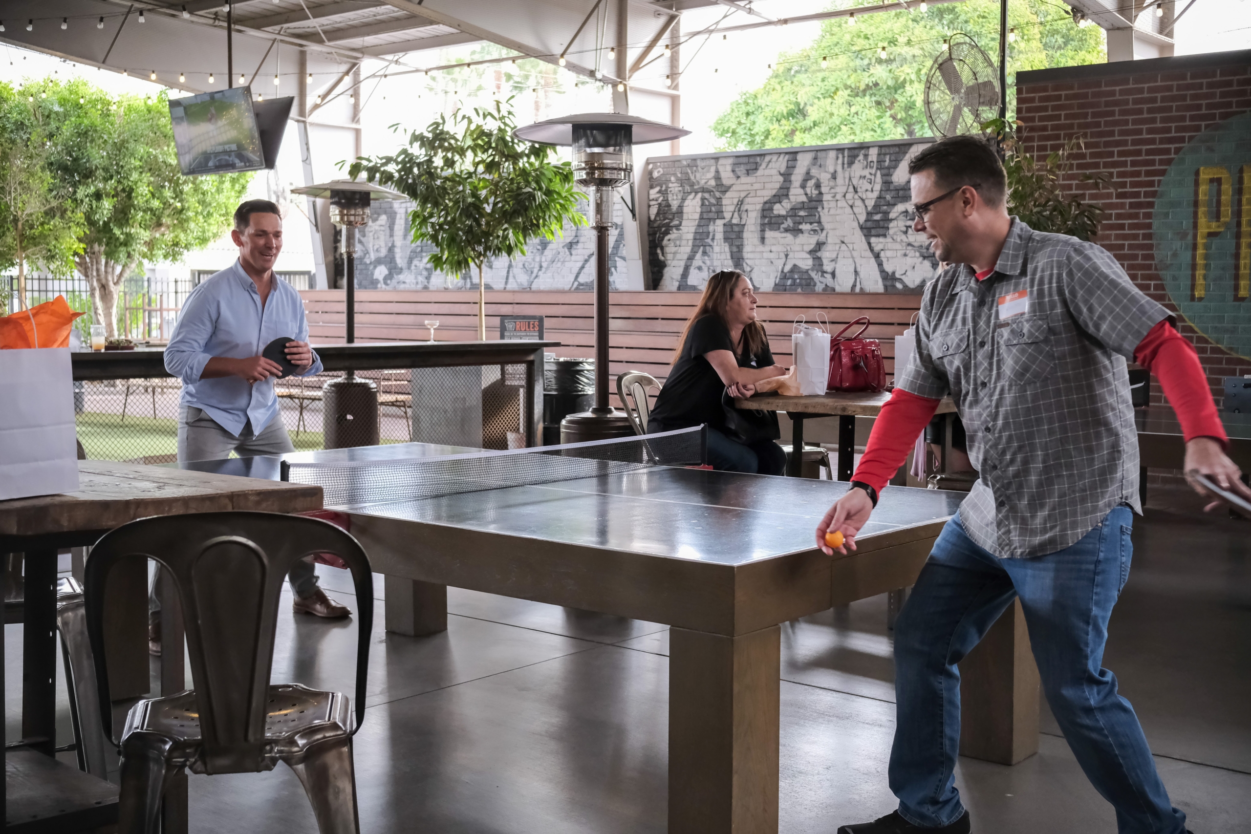 Televerde employees enjoying a friendly ping pong match, reflecting a culture of teamwork, balance, and employee well-being.