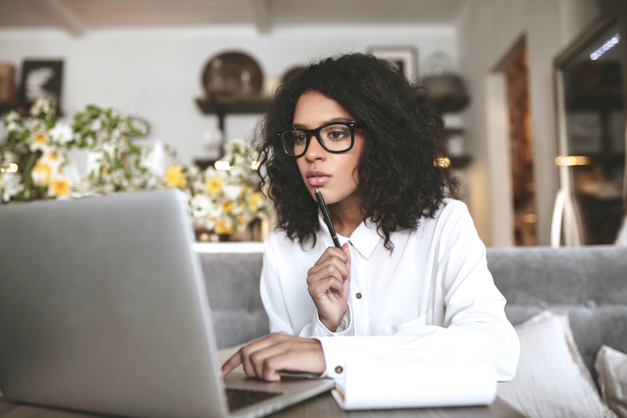 young business woman sits with laptop computer to learn about sales outsourcing ROI calculations
